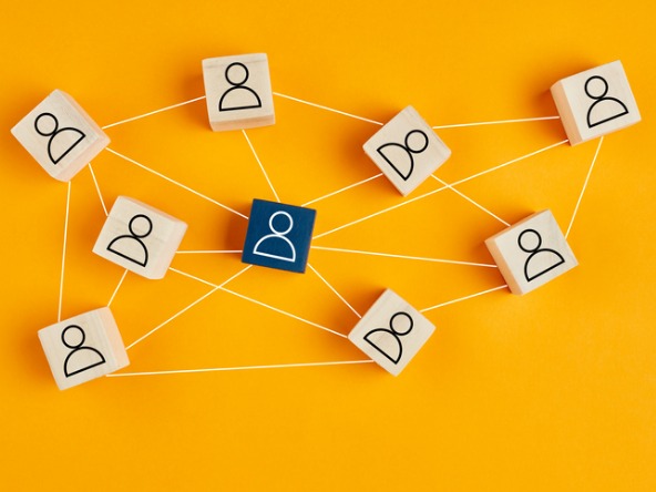 wooden blocks with outlines of people and linking through to each other, on a bright background
